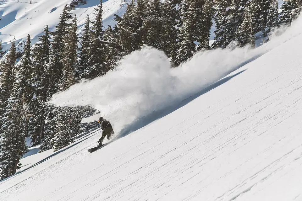 A snowboarder coming down Mammoth Mountain in fresh powder